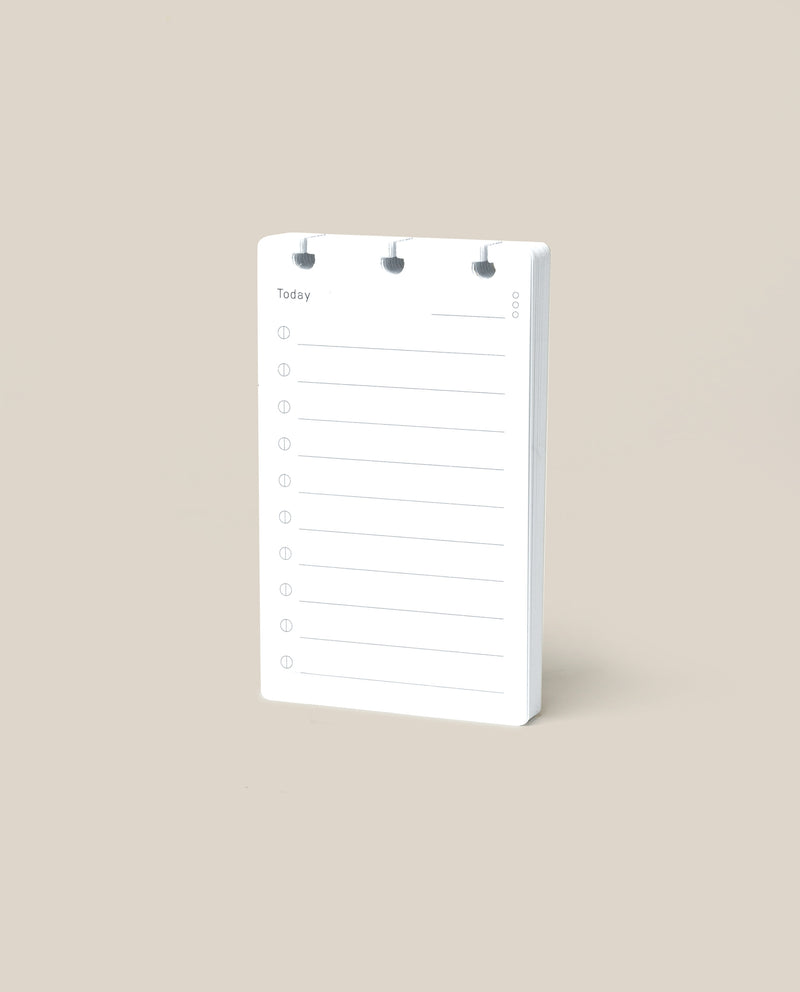 A Discbound Analog Refill (1-Pack), featuring lined pages for daily to-do lists, stands upright on a plain beige background.