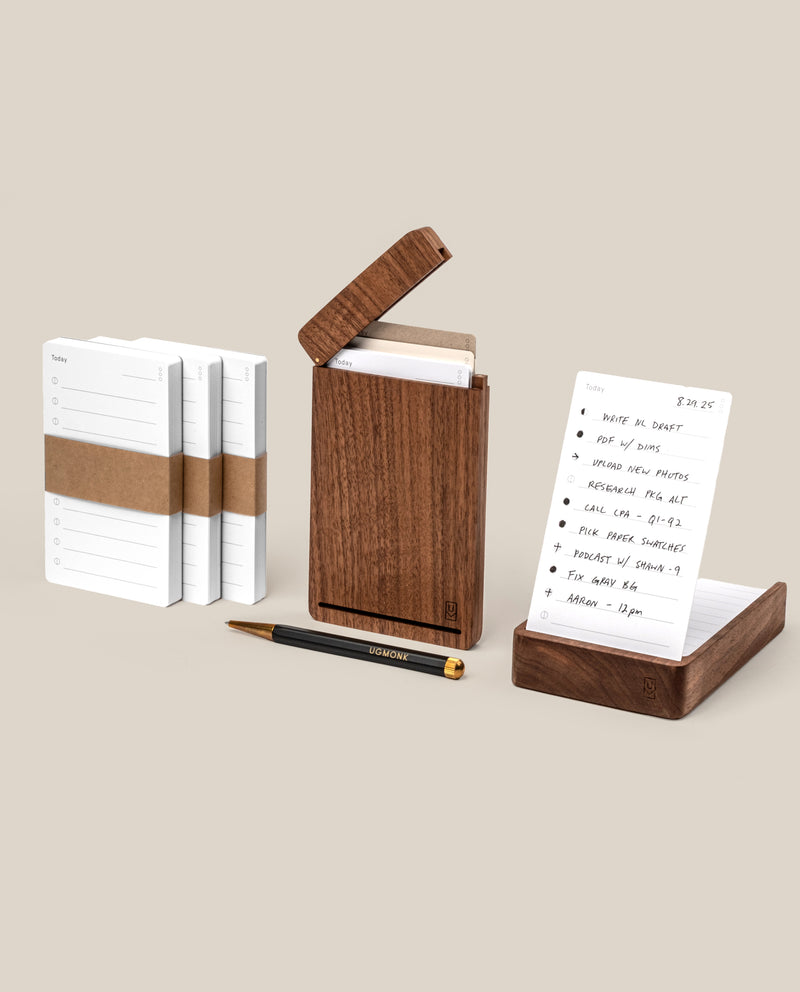 The Analog Bundle (Walnut), featuring note cards, a walnut card holder, a refillable pen, and a handwritten to-do notecard, is elegantly displayed on a beige surface—perfect for upgrading your desk.