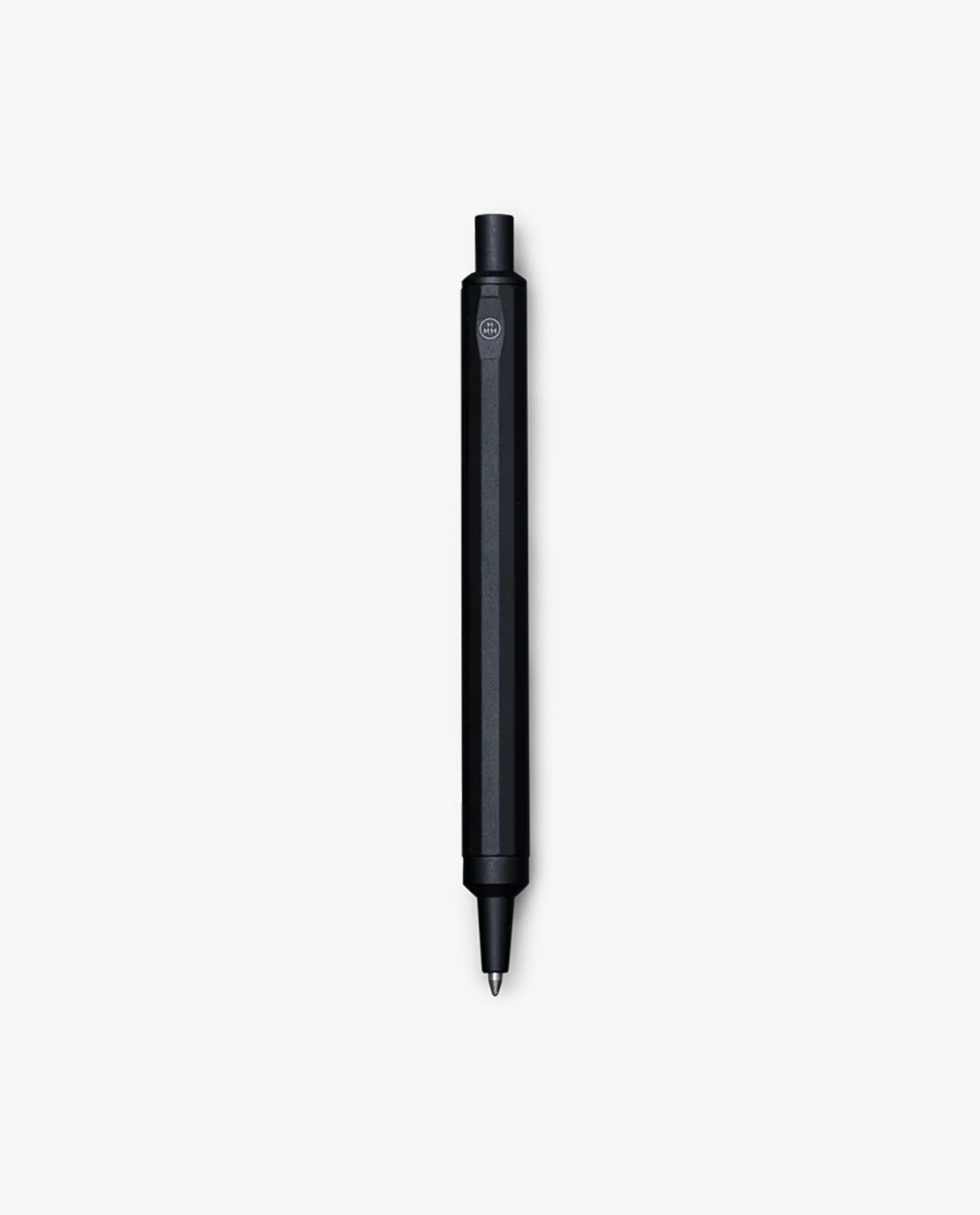 The HMM Ballpoint Pen (Black), featuring a hexagonal body, is centered on a plain white background. This refillable pen combines sleek design with everyday functionality.