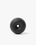 The HMM Paperweight Pen Stand (Black) is a circular aluminum piece with concentric raised rings and a central hole, shown on a plain white background.