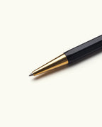 A close-up of The Ugmonk Pen (Leuchtturm1917 Drehgriffel - Black) with a gold tip, displayed diagonally on a plain white background.