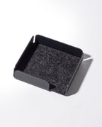 The Gather Note Tray (1x1 - Black) is a black, square-shaped magnetic desk organizer featuring low sides and a felt-lined bottom, photographed on a white background with a shadow falling to the right. Proudly made in the USA.