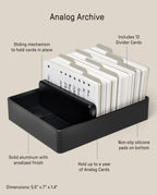 An Analog Archive (Black Aluminum) index card holder with a stack of white cards, 12 divider tabs, a sliding mechanism, and a non-slip base, designed for desk organization.