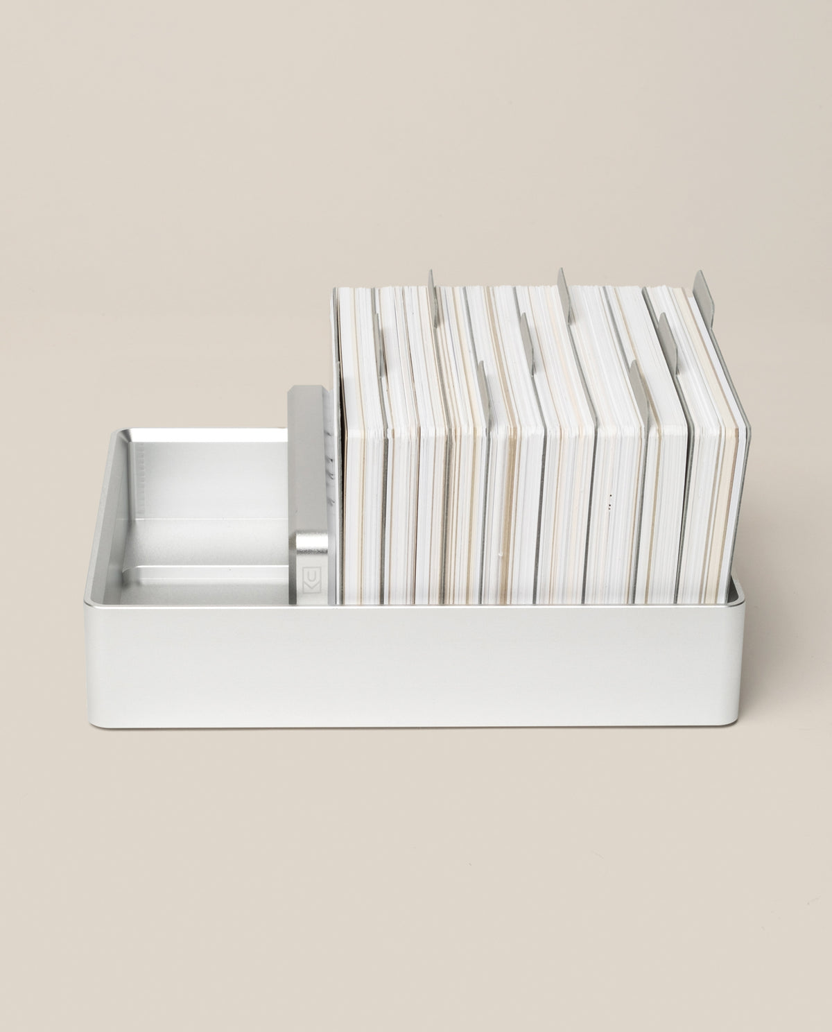 An Analog Archive (Silver Aluminum) desk organizer holding a stack of index cards separated by metal dividers.