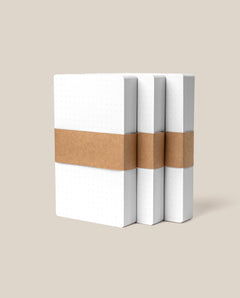 Three Analog Dot Grid Cards - Small (3-Pack) are stacked side by side, each wrapped with a wide kraft paper band for note taking, set against a plain beige background.