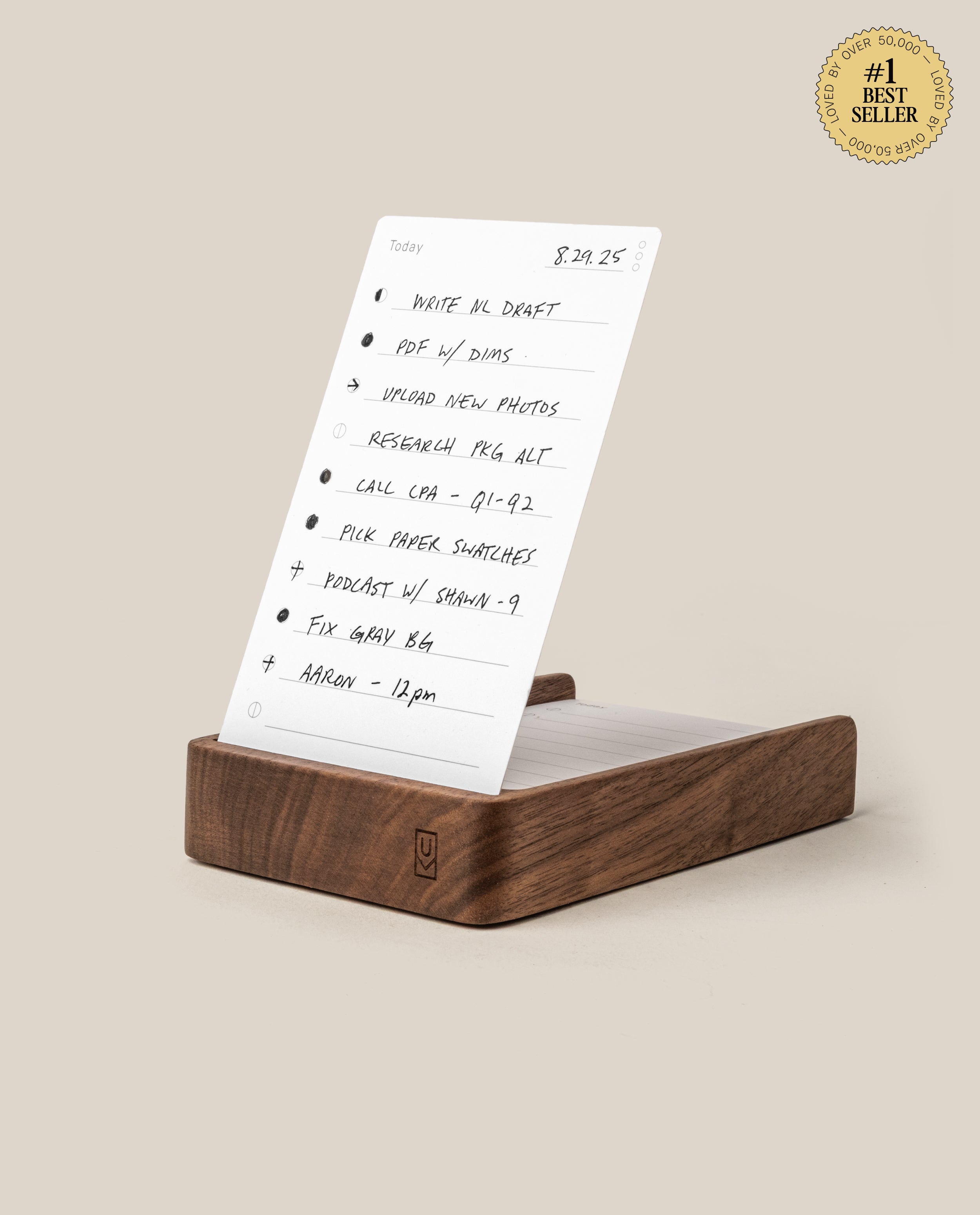 The Analog Daily Focus Kit (Walnut) stands upright on a wooden base like a card holder, displaying handwritten to-do lists with checkboxes. A #1 Best Seller gold badge appears at the top right on a beige background.