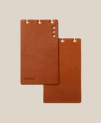 *Covers Only* – Leather Discbound Analog (Tan) includes two full-grain leather covers with rounded corners and 3 or 4 punched holes. One is embossed with "AnaLog," the other features a small symbol. Both are made in USA; beige background shown.