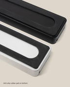 A black Analog Card Bar (Small 10") is shown from above on a light beige background, featuring large black anti-slip rubber pads on the bottom—ideal for complementing any desk organizer or pen tray setup.