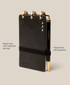 The Leather Discbound Analog (Black) is made from full-grain black leather, features three gold discs at the top, an elastic pen loop with a black and gold Ugmonk pen (sold separately), supports Analog Task Cards, and has four silver rivets on the right.