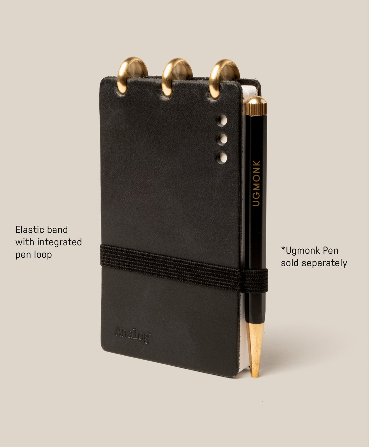 The Leather Discbound Analog (Black) is made from full-grain black leather, features three gold discs at the top, an elastic pen loop with a black and gold Ugmonk pen (sold separately), supports Analog Task Cards, and has four silver rivets on the right.