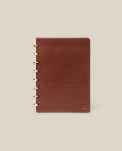 The Discbound Heirloom Journal (Brown Leather - Standard 6" x 8.5") with gold rings on the left edge is displayed on a plain beige background.