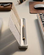 The Warehouse Item - Analog Card Bar (Small 10" - Silver) neatly displays note cards and holds a pen on a tidy desk alongside a keyboard, mouse, and other office supplies.