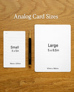 Two Analog Blank Cards—one labeled “Small” (3x5 in, 76x127mm), crafted from sturdy 100lb card stock and proudly made in the USA, and one labeled “Large” (5x6.5 in, 127x165mm)—rest on a wood surface with a black and gold pen between them. Text above the cards reads: “Analog Card Sizes.”.