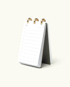 The Discbound Analog + 3 Refills is a stylish, refillable standing flip notepad with brass disc binding, shown open to a blank daily planner page with numbered lines—a perfect workspace task planner.