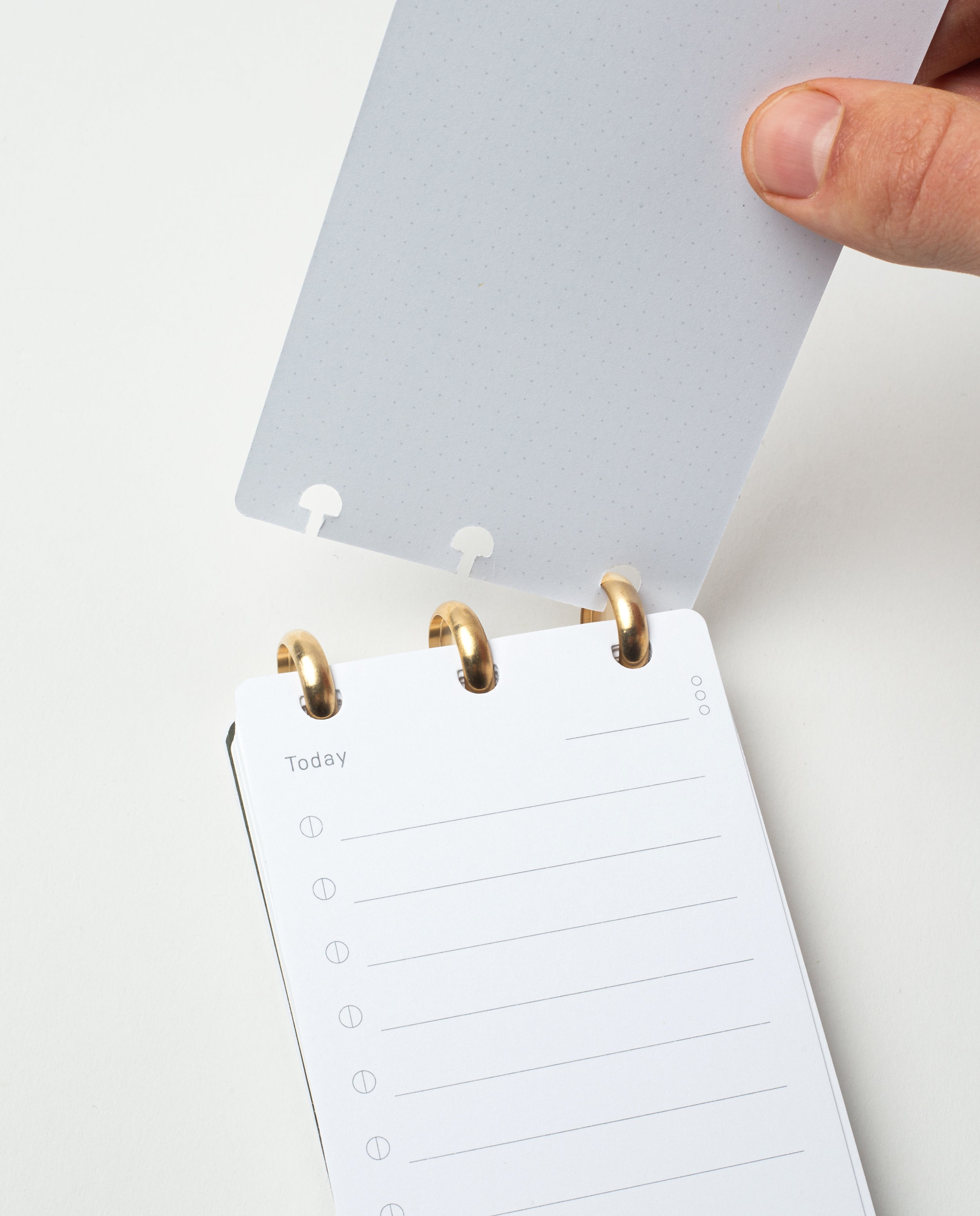 A hand opens the Discbound Analog + 3 Refills, featuring a dotted translucent cover and brass disc binding. Inside, a "Today" page offers lined circles for tasks—making it your ideal refillable daily task planner.