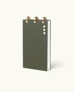 A compact, dark green Discbound Analog + 3 Refills notebook with brass disc binding and three white cover dots, shown upright against a light background—stylish and refillable for organizing tasks.