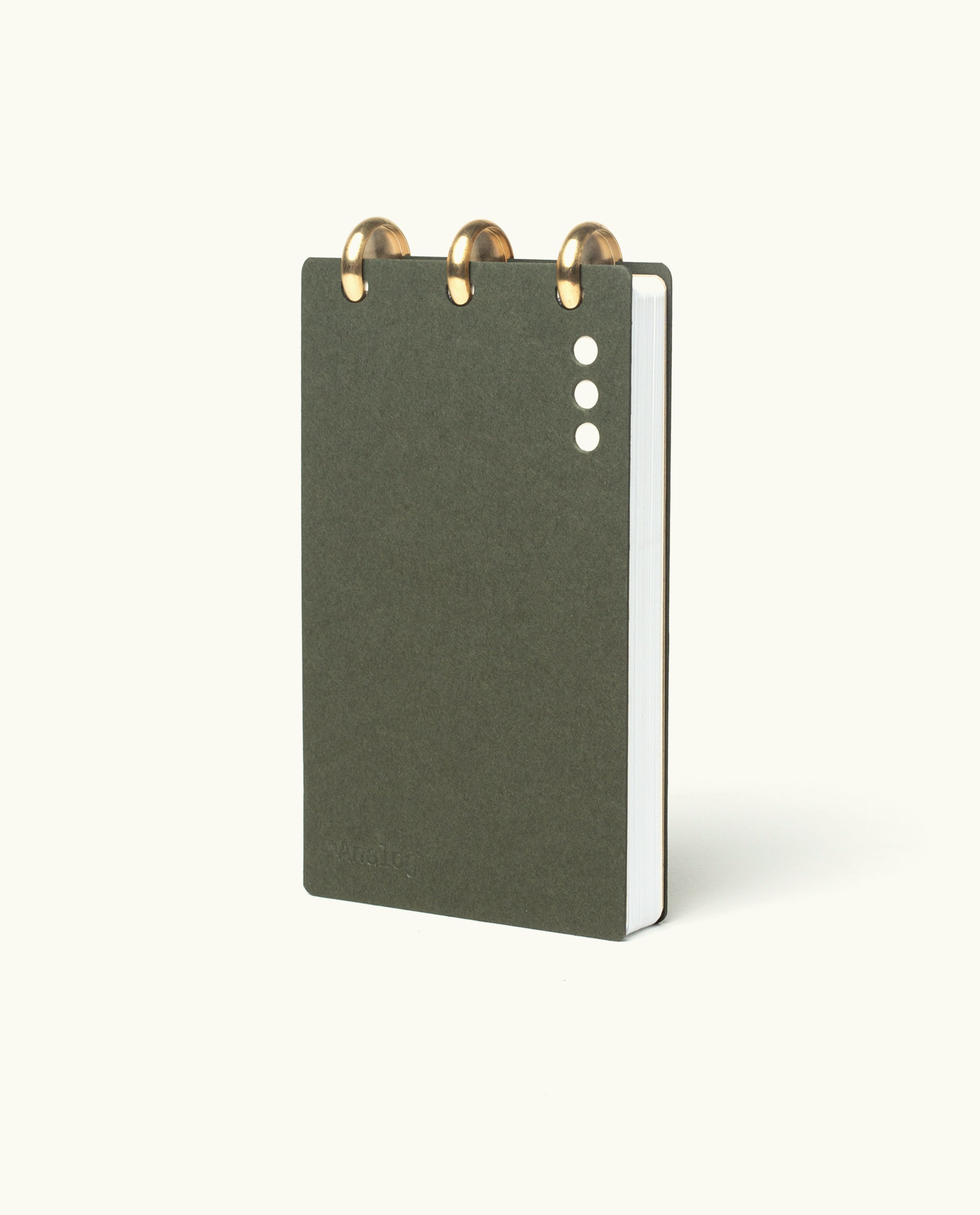 A compact, dark green Discbound Analog + 3 Refills notebook with brass disc binding and three white cover dots, shown upright against a light background—stylish and refillable for organizing tasks.