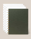 A set of four Discbound Journal Bundles (8.5" x 11" Journal + 3 Refills), each spiral-bound with dotted pages, is arranged in a partially overlapping stack. The top journal displays a dark green cover, while the three beneath it feature white covers. Set against a light beige background, each refillable notebook is elegantly bound with sturdy brass discs for enhanced durability and sophistication.