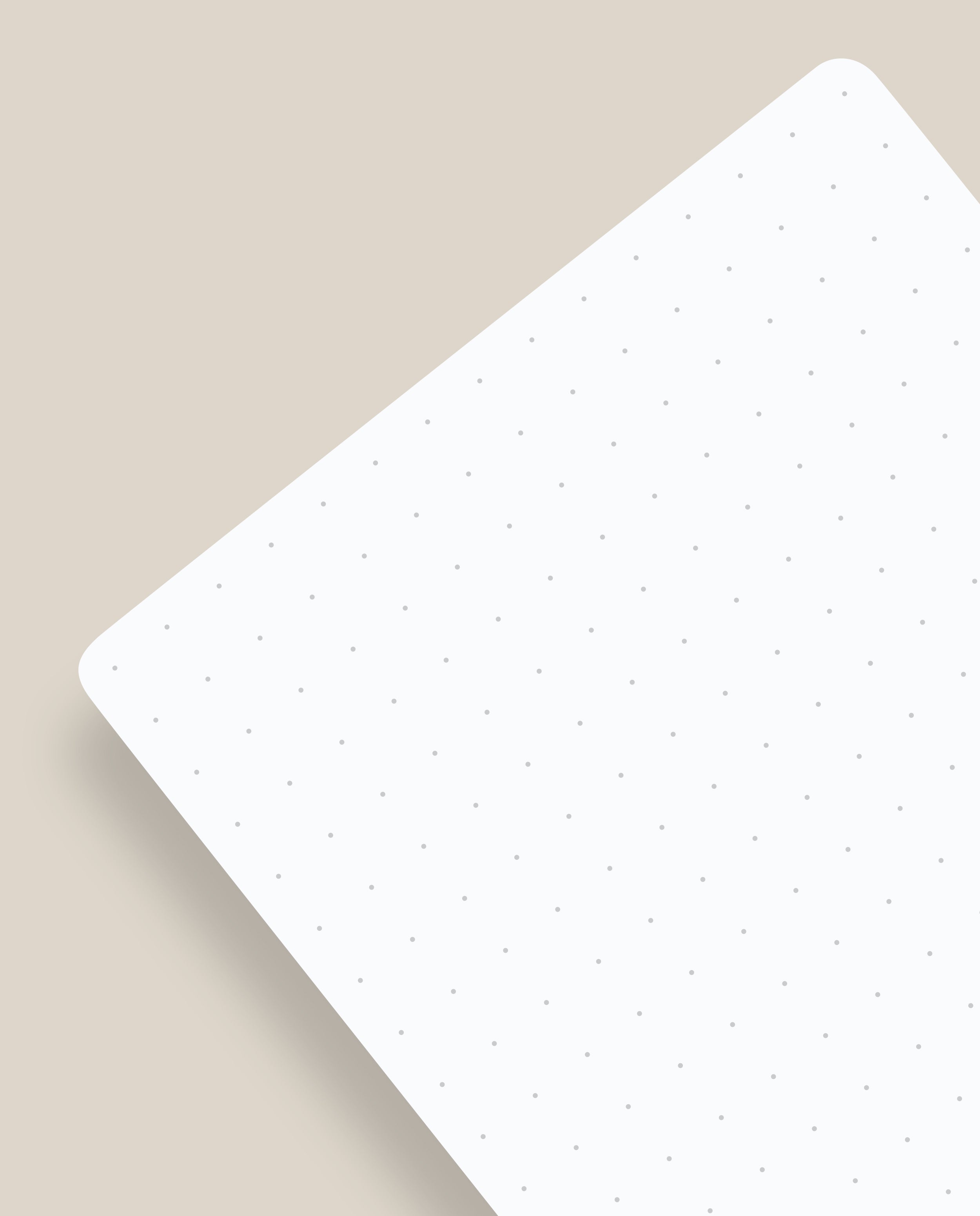 A pack of Analog Dot Grid Cards - Small (3-Pack) rests at an angle on a light beige surface, featuring subtle gray dots for easy note taking and casting a soft shadow to the left.