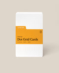 A stack of Analog Dot Grid Cards - Small with a white cover, orange label, and dotted grid. Includes 50 cards (3x5in) made from 100lb uncoated cardstock—perfect for sketching ideas.