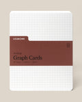A pack of Analog Graph Cards - Large with a white grid background, brown label reading “Graph Cards, 50 Cards, 5x6.5in, 100lb,” and rounded corners. Made from sturdy uncoated cardstock for sketching, brainstorming, or note-taking.
