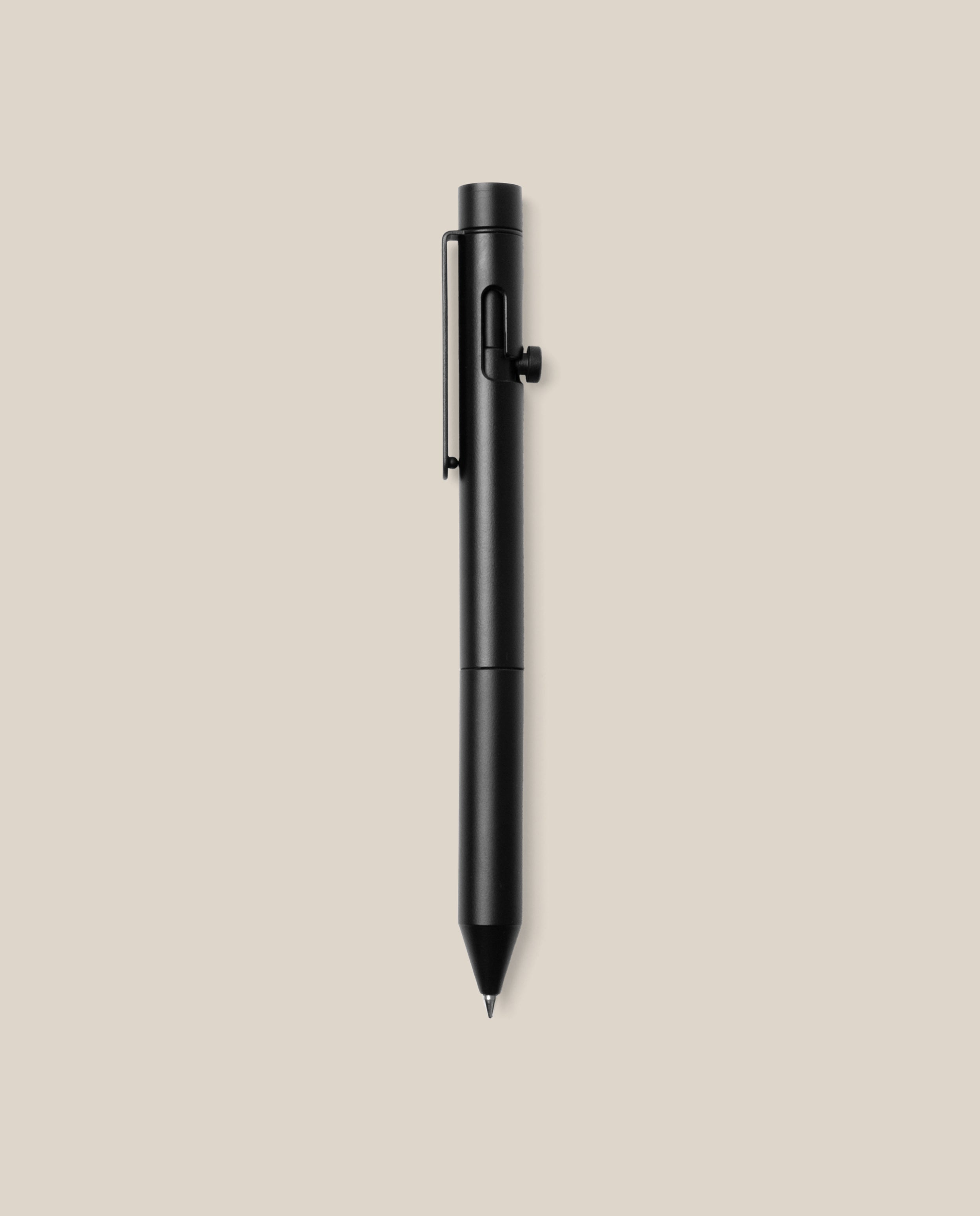 An INVENTERY Bolt Action Pen (Onyx) with a clip is centered on a plain beige background, its sleek black Cerakote ceramic coating providing both durability and style.
