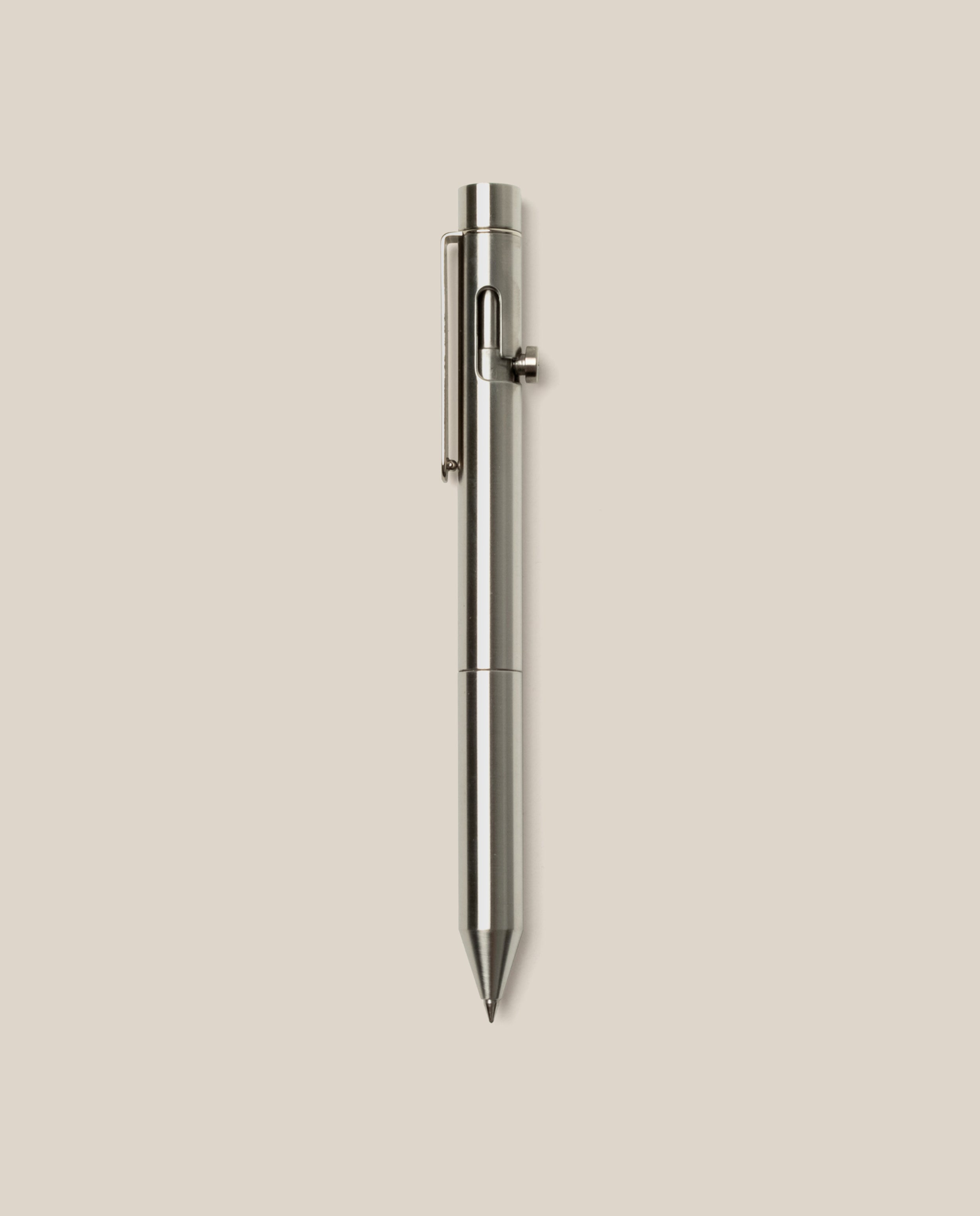An INVENTERY Bolt Action Pen (Stainless) with a sleek clip is centered vertically on a plain light beige background.