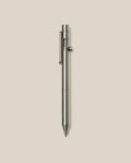 An INVENTERY Bolt Action Pen (Stainless) with a sleek clip is centered vertically on a plain light beige background.