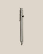 An INVENTERY Bolt Action Pen (Stainless) with a sleek clip is centered vertically on a plain light beige background.