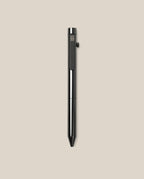 The INVENTERY Bolt Action Pen (Zirconium) stands vertically on a plain beige background, showcasing its luxurious black metal finish, side button, and sleek clip—an elegant luxury writing instrument for discerning users.