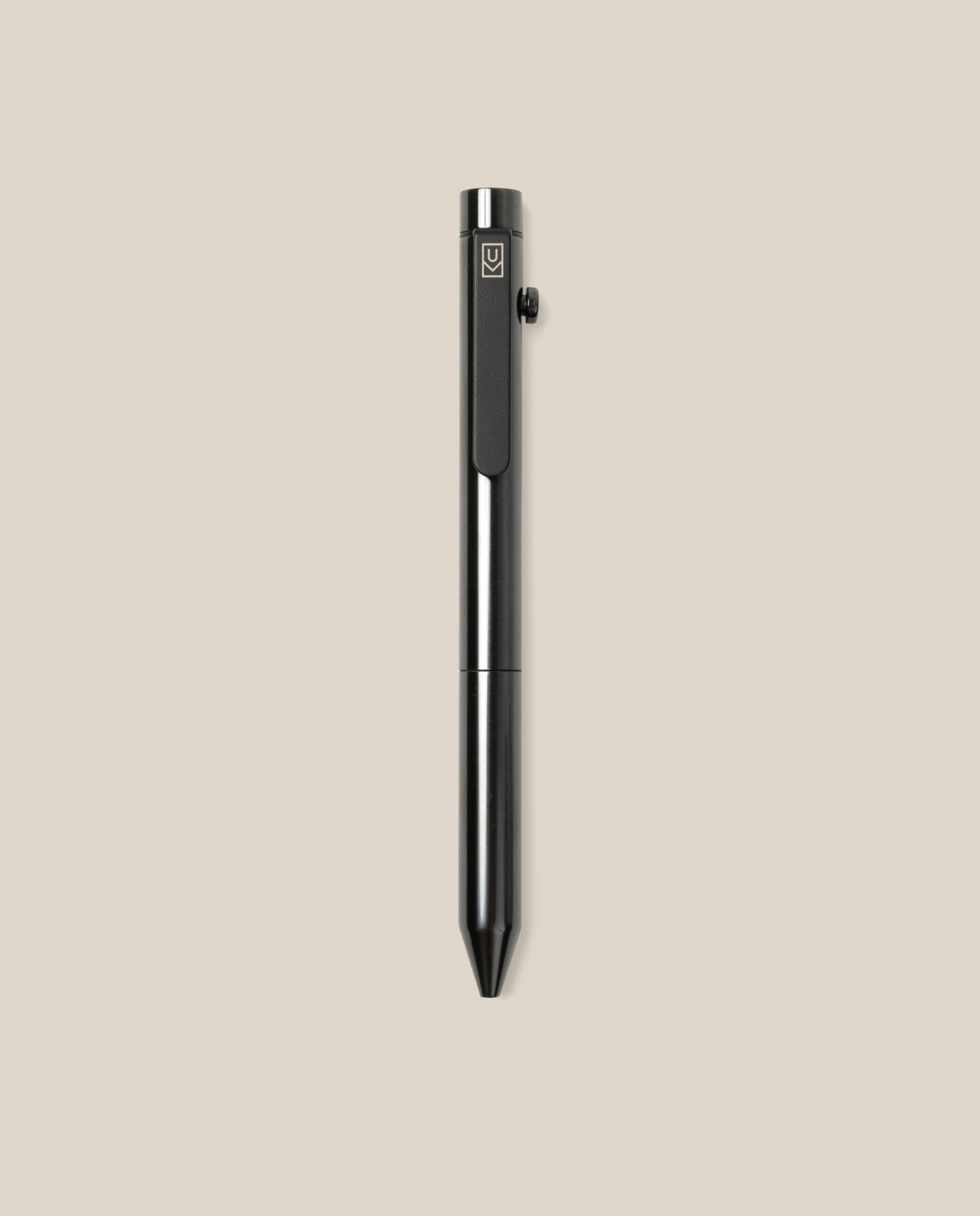 The INVENTERY Bolt Action Pen (Zirconium) stands vertically on a plain beige background, showcasing its luxurious black metal finish, side button, and sleek clip—an elegant luxury writing instrument for discerning users.