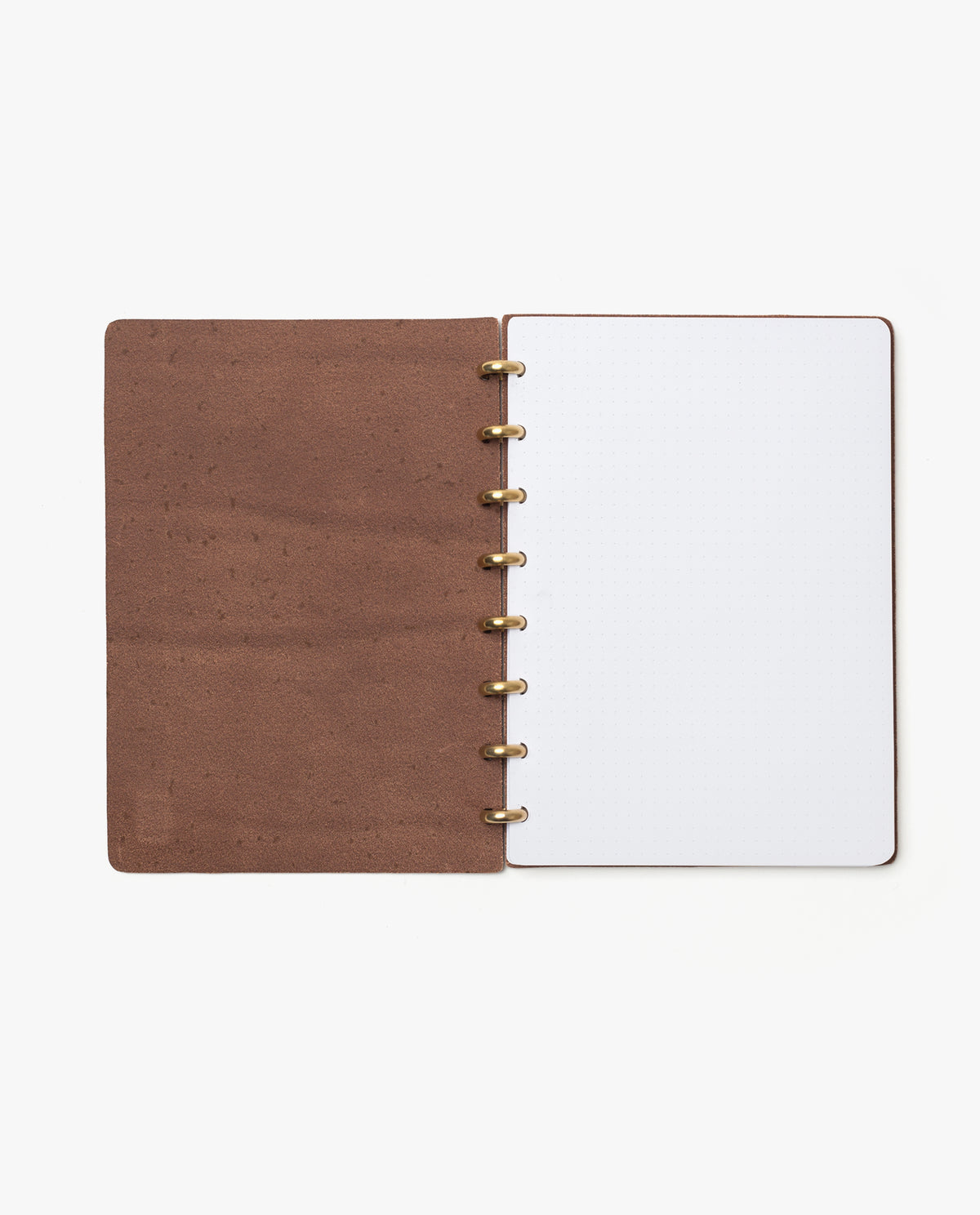 The Warehouse Item - Discbound Heirloom Journal (Brown/Brass) is shown open on a white background, featuring full grain leather covers, brass metal rings, and a blank white dotted page on the right. This elegant refillable discbound journal is perfect for customization and note-taking.