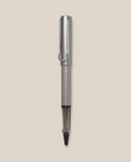 A graphite LAMY AL-star Rollerball with a sleek design stands vertically against a light beige background, highlighting its smooth writing performance and stylish, refillable rollerball pen construction.