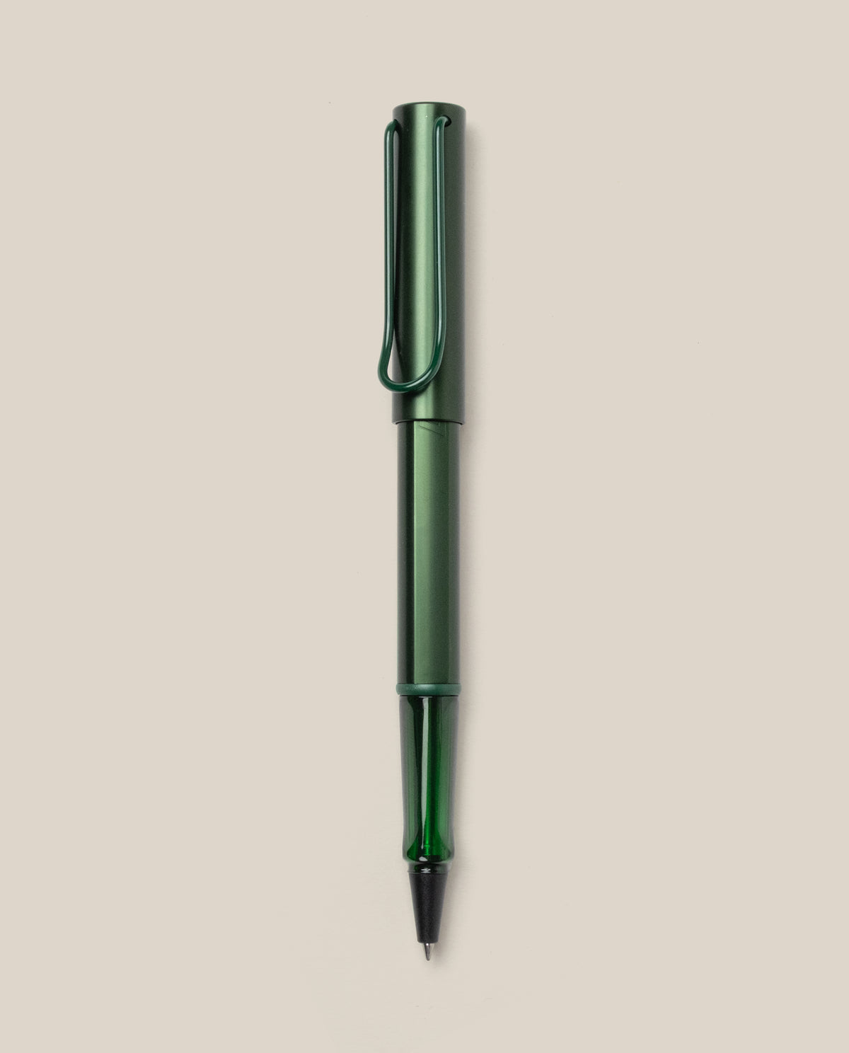 A LAMY AL-star Rollerball (Pine) pen in green metallic, with matching cap and clip, is displayed vertically on a plain light beige background. This refillable pen ensures smooth, effortless writing.