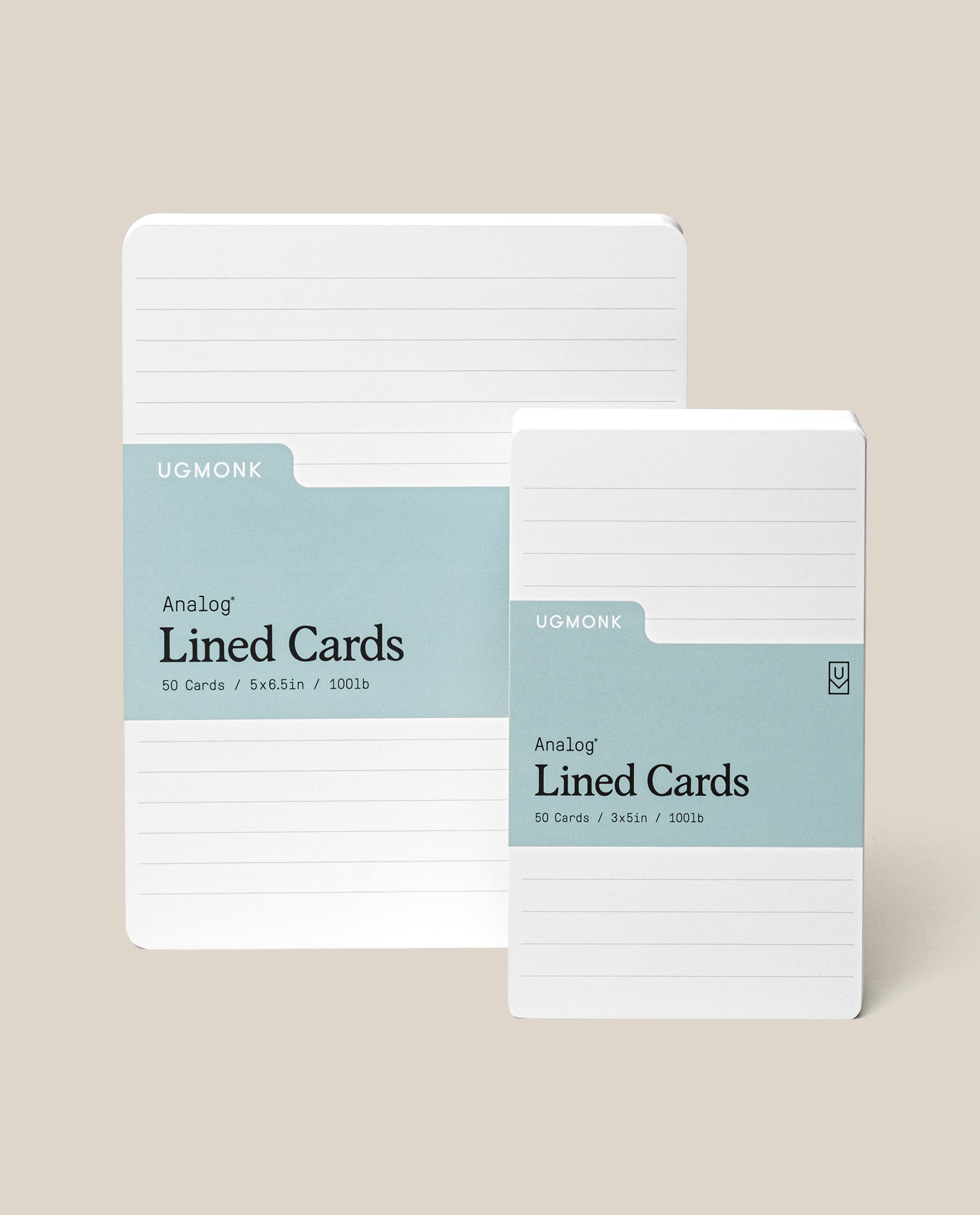 Two stacks of white lined cards with blue-green labels, branded UGMONK Analog Lined Cards. One stack is larger (5x8.5in), and the other is smaller (3x5in), both with rounded corners on a beige background.