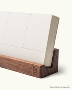The Analog Weekly Card Holder (Walnut) is handcrafted in Pennsylvania and displays a stack of Weekly Cards showing T and F, with a logo on the front. *Weekly Cards sold separately.