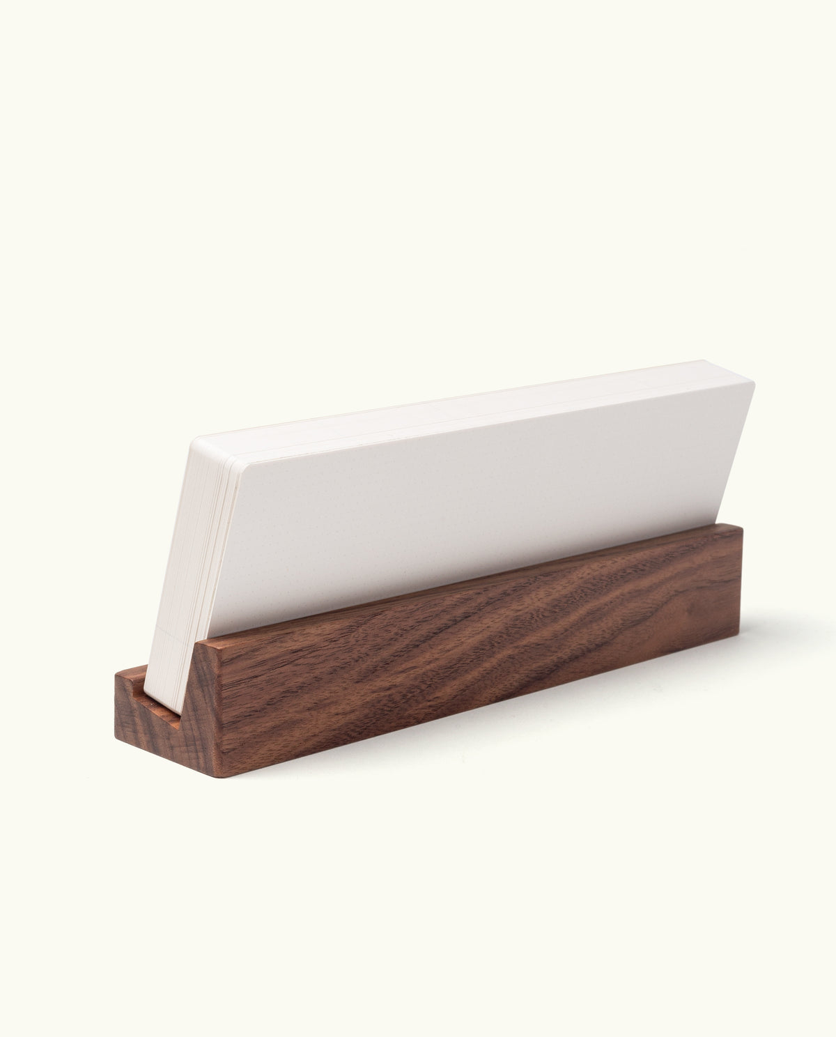 A stack of blank white cards stands upright in a rectangular walnut holder against a plain white background, highlighting the simplicity and elegance of the Analog Weekly Planning Kit (Walnut).