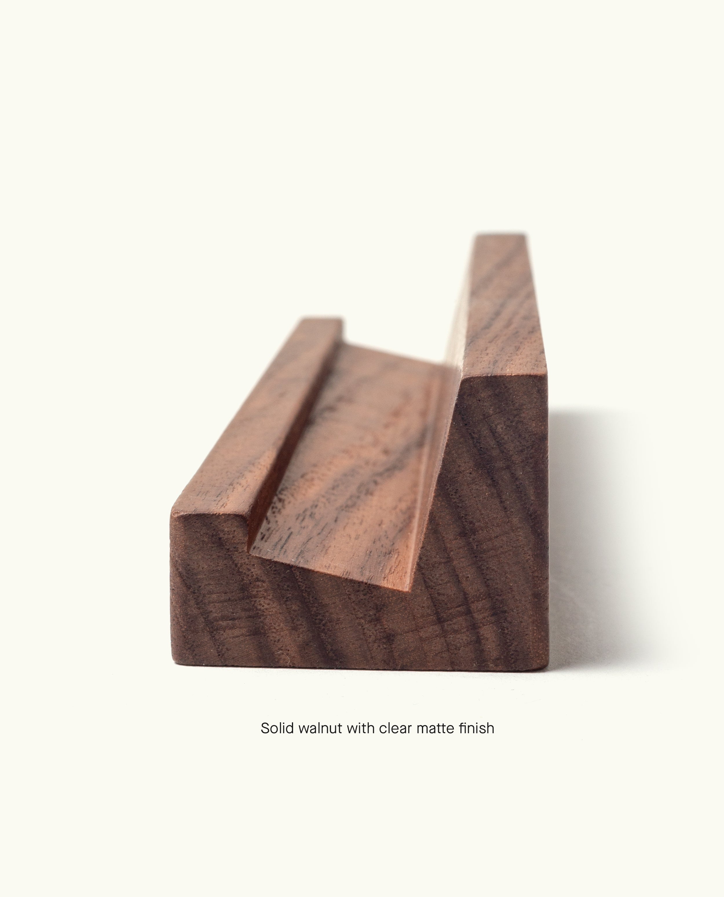 The Analog Weekly Card Holder (Walnut) features a handcrafted walnut design with a clear matte finish and grooved slot, made in Pennsylvania. Photographed on a plain light background, it’s ideal for displaying your Analog Weekly Cards in style.