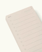 Analog - Next Cards are minimalist notepads inspired by analog design, featuring the word “Next” at the top left, ten blank lines each with a circle for easy tracking, and three small circles stacked at the top right. The notepad comes in a light beige color and is photographed against a white background. Ideal for goal setting and organizing your thoughts with clarity.