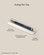 The Analog Pen Tray (Silver Aluminum) is a sleek, anodized solid aluminum desk accessory with non-slip pads and a V-shaped groove to secure your pen. Holds a black and gold pen. Dimensions: 5.77 x 1.33 x .62 inches.