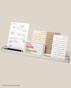 The Analog Card Bar (Large 16" – Silver) is a minimalist solid aluminum desk organizer that holds several task cards featuring sketches, lists, and charts, as well as a black pen and gold pencil. *Cards sold separately.