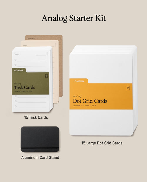 The Analog Starter Kit (Black) features green task cards as part of its innovative paper card system, tan divider cards, white Dot Grid Cards, and a black aluminum card stand displayed on a neutral background.
