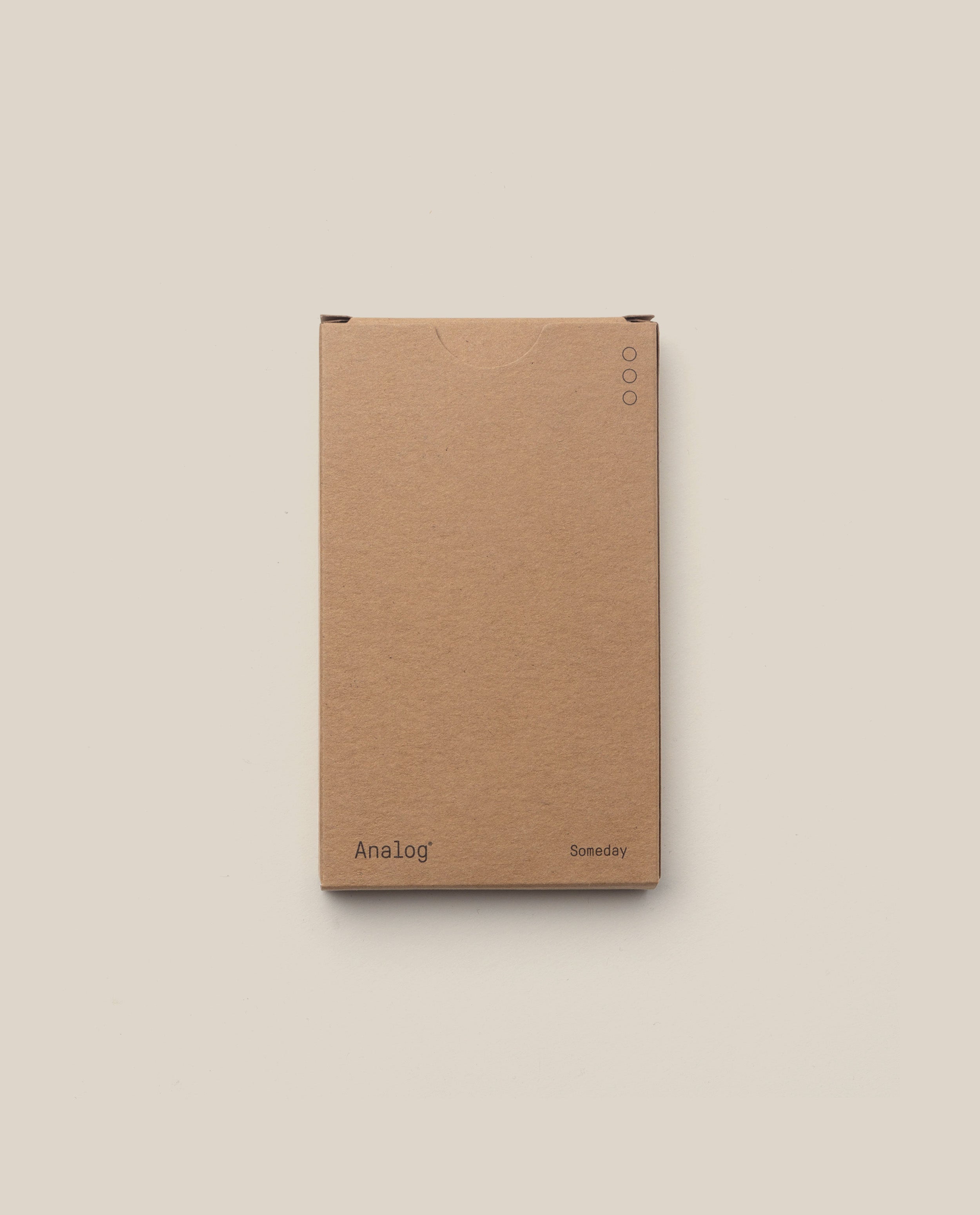A plain brown box labeled "Analog" (bottom left) and "Someday" (bottom right), shown on a light beige background, features three small circles top right—ideal for storing your Analog - Someday Cards (1-Pack).