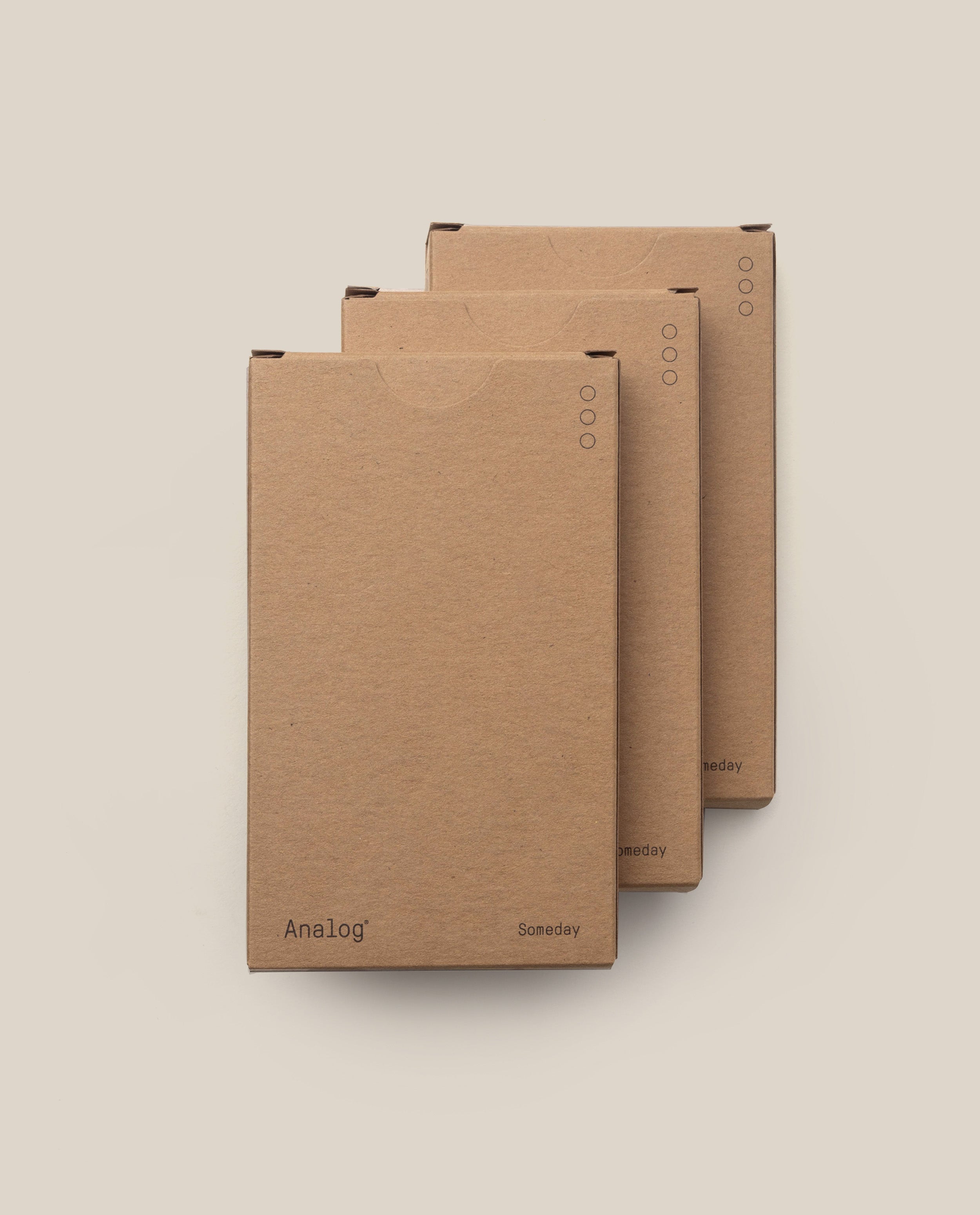 Three brown Analog - Someday Cards (3-Pack) boxes, made in the USA, are arranged in a staggered row against a light beige background. Each minimalist box displays black lettering and small circular icons in the upper right corner.