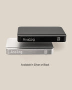 Two rectangular metal cases, one black and one silver, each labeled “Analog” with a small logo. The Analog Starter Kit (Silver) is designed as an elegant aluminum card stand for task cards or any paper card system. Text below reads: Available in Silver or Black.