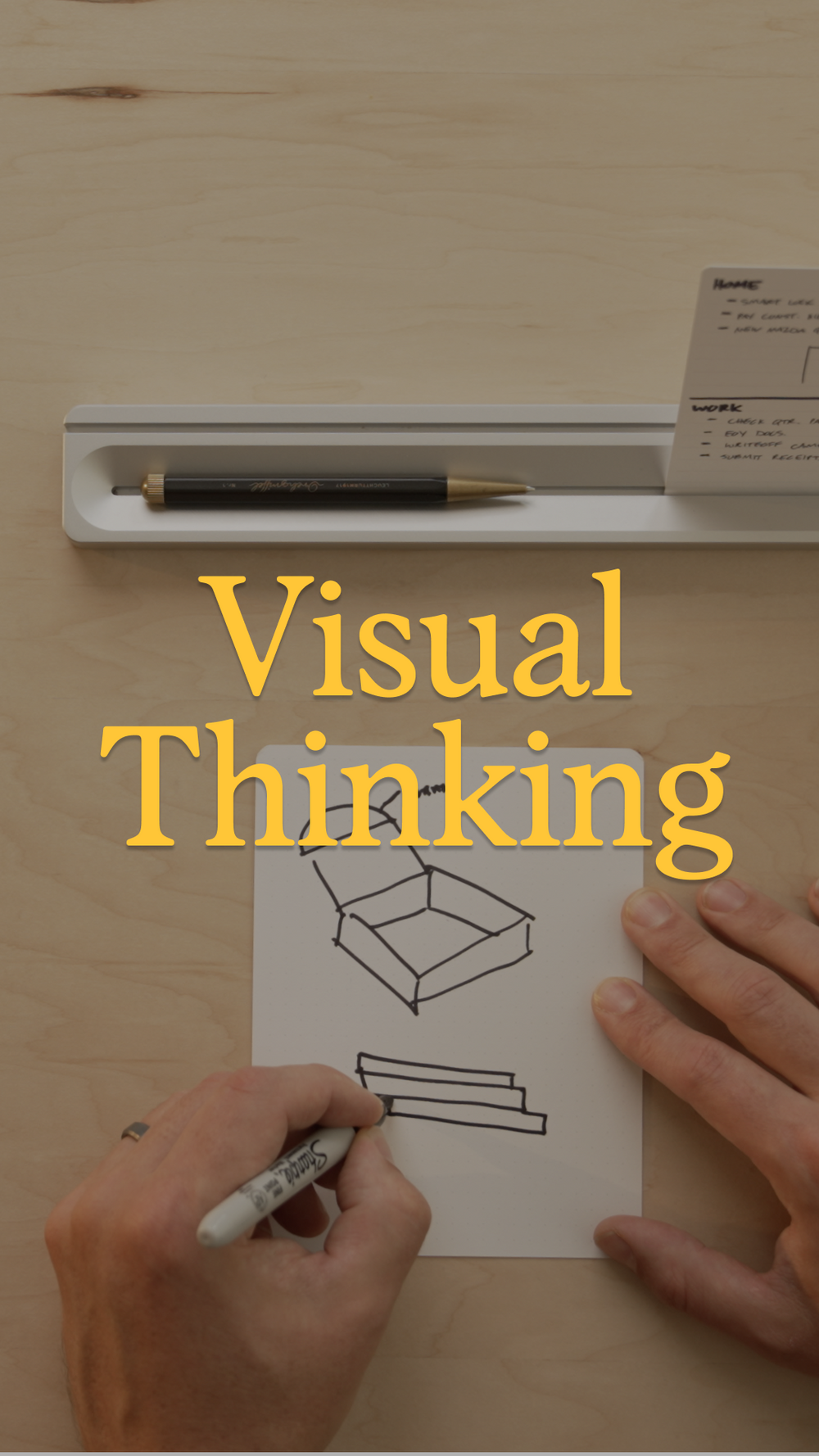 A person draws a 3D box diagram on paper with a marker. A pen, paper, and small note are nearby. The words Visual Thinking appear in large yellow text over the image.