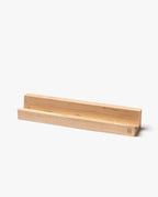 A minimalist, handcrafted maple Analog Weekly Card Holder made in Pennsylvania, featuring a groove to hold items upright. This rectangular, light-colored stand is shown against a plain white background.