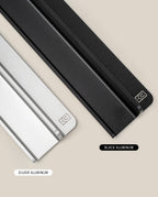 Two aluminum desk organizers—a silver Aluminum Card Stand and a black Analog Weekly Planning Kit—are shown on a beige background, both with a small logo labeled SILVER ALUMINUM and BLACK ALUMINUM.