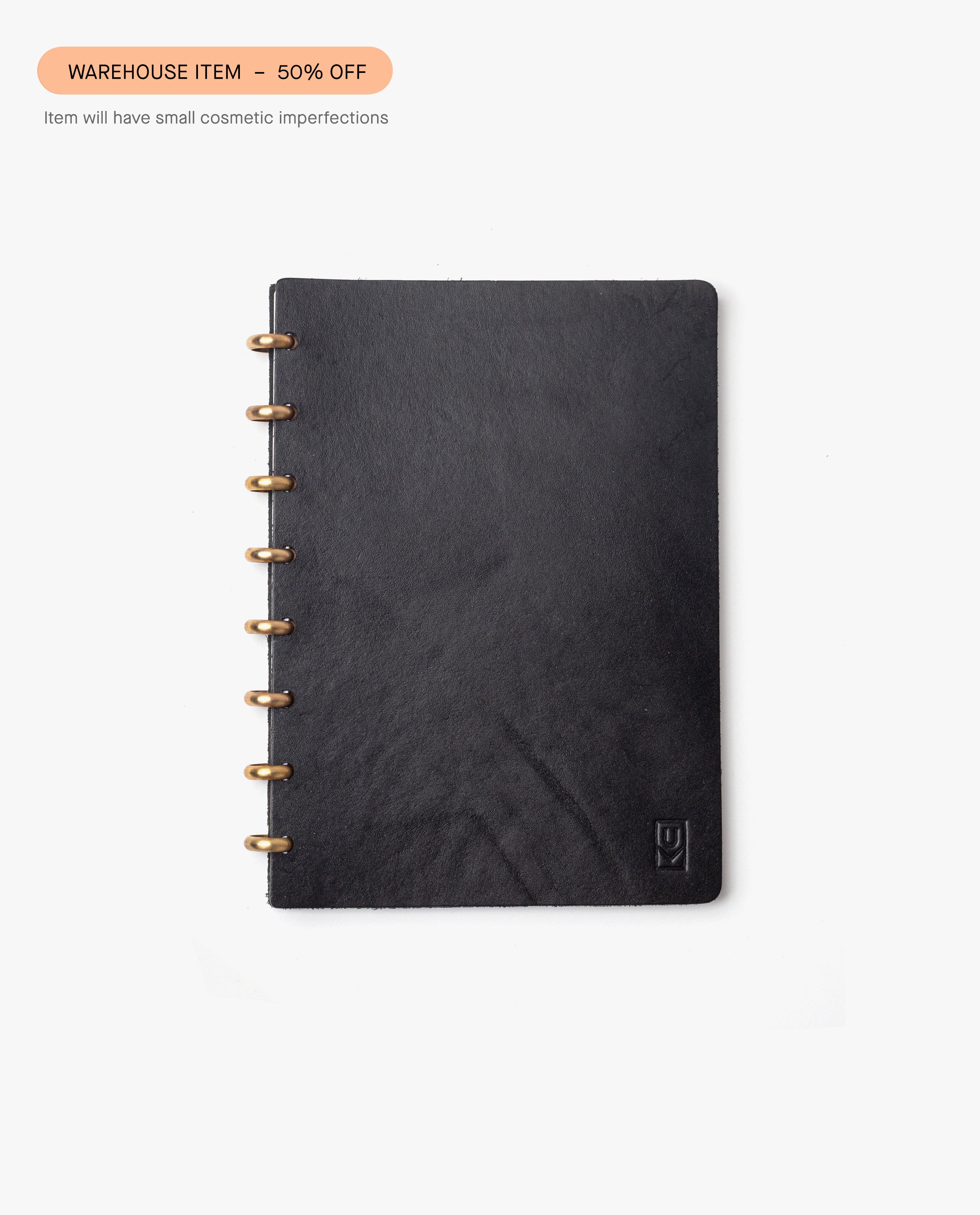 The Warehouse Item - Discbound Heirloom Journal (Black/Brass) is shown centered on a white background with a "WAREHOUSE SALE – 50% OFF" label above. Item may show minor cosmetic imperfections.