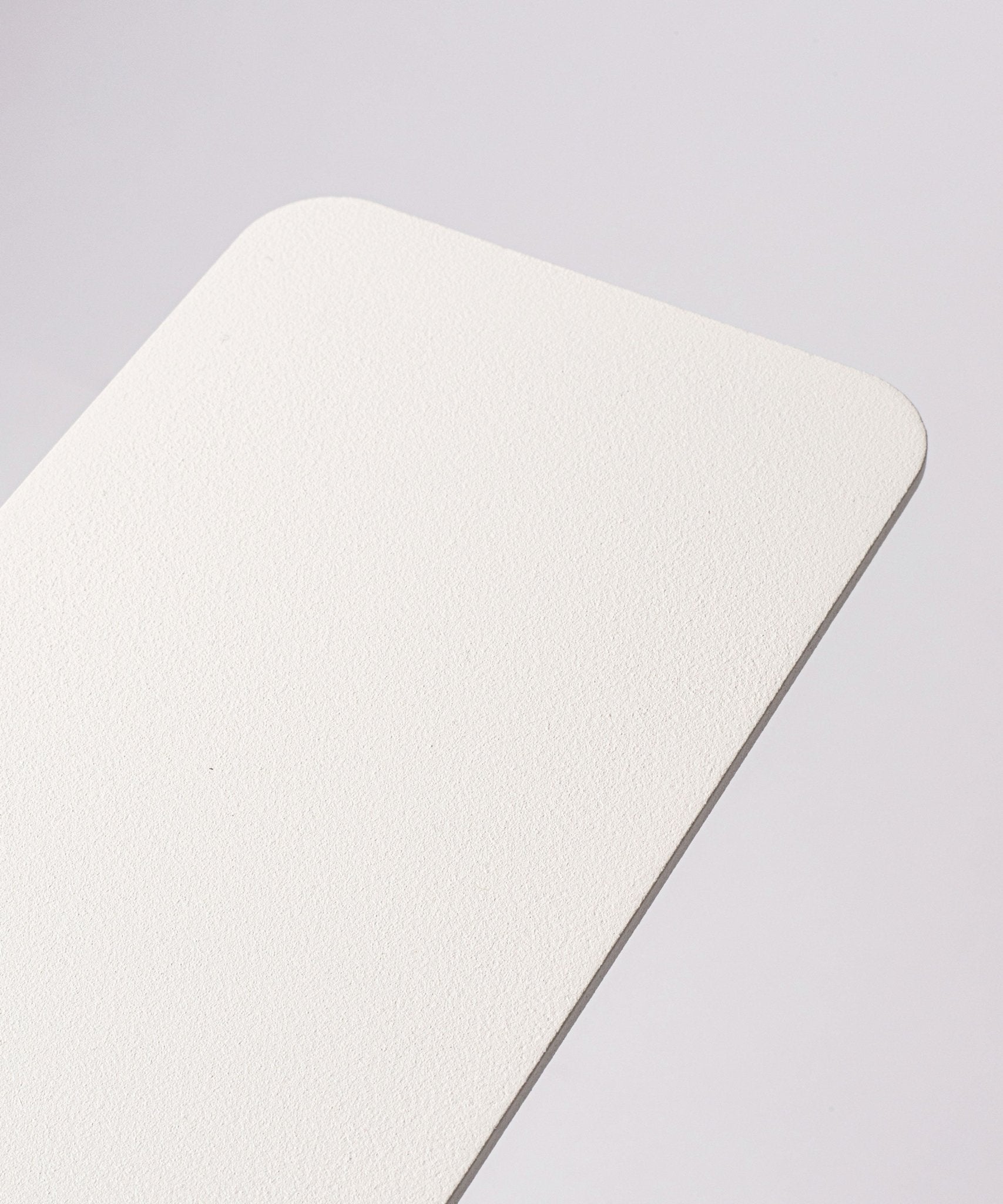 A close-up of the corner of the Gather 1x4 Base Plate (White), a rectangular object with a textured powder-coated steel surface, set against a plain light background.